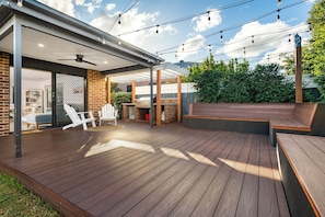 Outdoor entertaining space with deck, furniture, BBQ and drinks fridge.