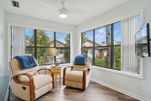 Windowed Sitting Nook – 308 Harbour Oaks - This quiet corner inside 308 Harbour Oaks features two cushioned chairs and panoramic windows—perfect for morning coffee, journaling, or winding down after a day on St. Simons Island.