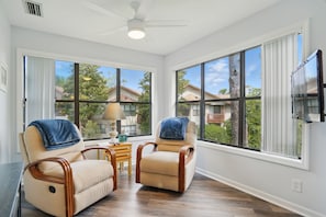 Windowed Sitting Nook – 308 Harbour Oaks - This quiet corner inside 308 Harbour Oaks features two cushioned chairs and panoramic windows—perfect for morning coffee, journaling, or winding down after a day on St. Simons Island.