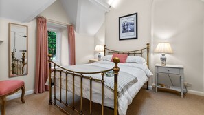 The master bedroom has a king-size bed with touches of blush pink