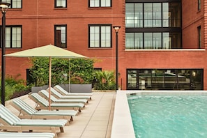 Pool area with striped chairs and tall windows
