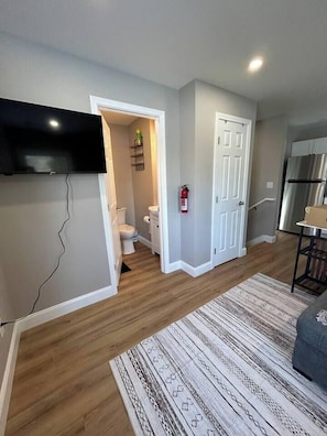 50" TV, looking into bathroom, closet will have bath towels for the amount of guests in your stay, and you can see the stairs down to the bedrooms.