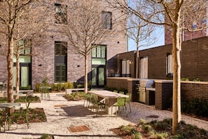 Courtyard with trees, grill, and dining table
