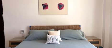 King sized bed with cotton sheets and pool towels