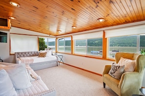 Enjoy peaceful lakeside views from this cozy sunroom, complete with plush seating for ultimate relaxation. 🌅🛋️🌊