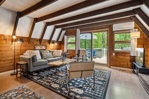 The main living area! There is a smart tv with cable and the ability to login to your own streaming platforms. There is also air conditioning! Access to the deck and hot tub is right out the patio door. Black out curtains throughout