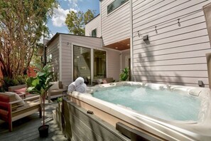 The outdoor space features a hot tub and seating area.