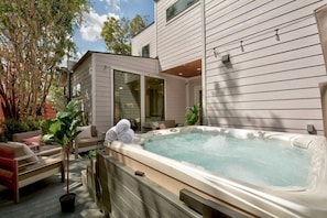 The outdoor space features a hot tub and seating area.