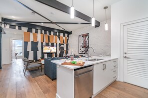 Fully equipped kitchen featuring stainless steel appliances, open counter space, and bar seating for 4 guests.