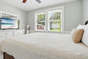 Queen Bedroom with Ensuite + Smart TV - This queen bedroom includes a private ensuite bath and a wall-mounted smart TV—ideal for winding down with a movie or claiming your own space during group trips. Plantation shutters let you block the light when it’s time to sleep in (you’re on island time, after all).