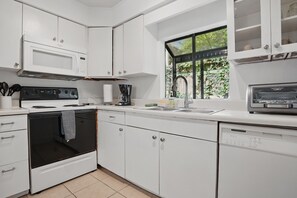 Kitchen – Bright, Efficient, and Ready to Roll - The kitchen at 412 Magnolia Avenue keeps it classic. Bright white cabinetry, a full-size fridge, and a regular drip coffee maker mean everything you need is within reach—without trying too hard. Cook, reheat, or just stock the fridge with leftovers from Iguanas, Porch, or Georgia Sea Grill (all a short walk away).
