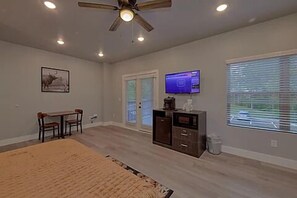 One room studio condo with king bed, tv, microwave, refrigerator, and coffee maker.