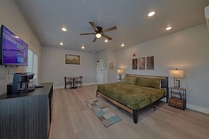 Spacious one room condo has a king bed with tv, microwave, refrigerator, and coffee maker.
