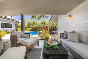 Cozy spot to sit back, relax, and enjoy views of the pool and tropical garden.