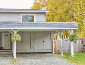 Front exterior with covered parking for 1 and uncovered parking for 2.