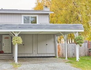 Front exterior with covered parking for 1 and uncovered parking for 2.