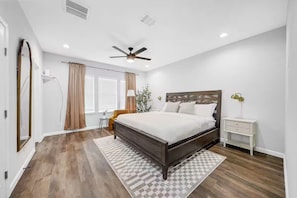 Master bedroom with a comfy chair and wall mounted smart TV