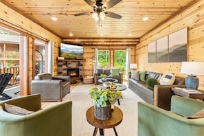 Main living area with plenty of seating, fireplace, and large TV.