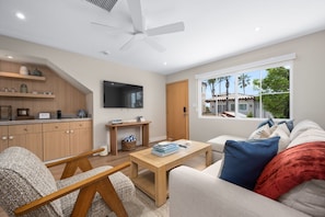 This thoughtfully curated first-floor unit boasts a neutral palette with coastal accents, a spacious sofa with a chaise, and a streaming-ready smart TV. The natural wood tones and cozy textures create a relaxed, modern vibe that feels like home.