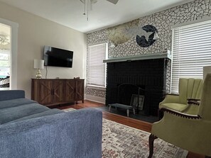 Cozy living room with pullout couch, smart TV & custom fish tile work.