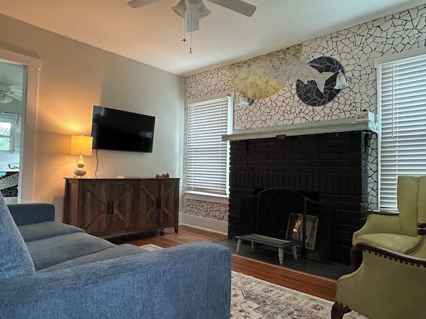Cozy living room with pullout couch, smart TV & custom fish tile work.