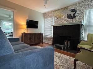 Cozy living room with pullout couch, smart TV & custom fish tile work.