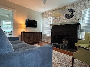 Cozy living room with pullout couch, smart TV & custom fish tile work.