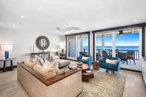 Living room with Floor To Ceiling Glass Doors offering Expansive Ocean Views