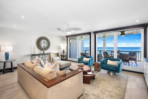 Living room with Floor To Ceiling Glass Doors offering Expansive Ocean Views