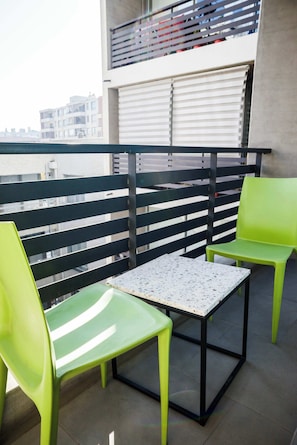 Enjoy your morning coffee on this cozy balcony with urban views, perfect for a relaxing start to your day.
