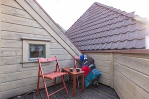 Roof terrace with red chairs and sweeping rooftop views