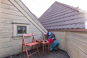 Roof terrace with red chairs and sweeping rooftop views