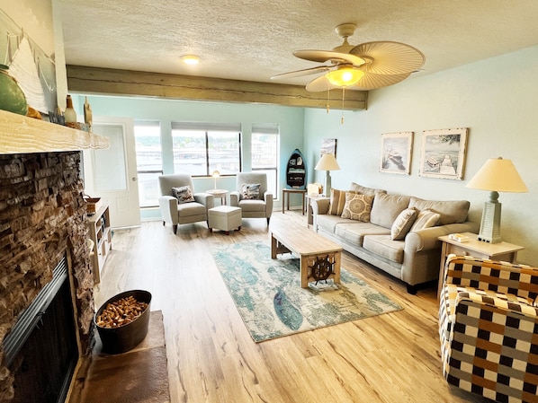 Large living room with ample seating large tv wood burning fireplace lake view