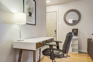 Dedicated workspace in the living room with a desk, lamp, and comfortable chair for remote work or planning your day.


