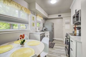 Bright and fully stocked kitchen with stainless steel appliances, granite counters, and a cheerful breakfast nook for casual meals.

