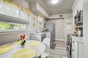 Bright and fully stocked kitchen with stainless steel appliances, granite counters, and a cheerful breakfast nook for casual meals.