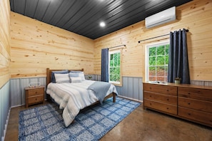 Bedroom: Rustic charm meets modern comfort in this beautifully appointed bedroom, offering a truly unique stay.