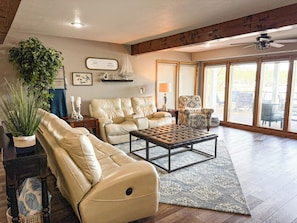 Spacious living room with leather recliners, smart TV, and direct access to the lakeview deck—gather here after a day on the water.