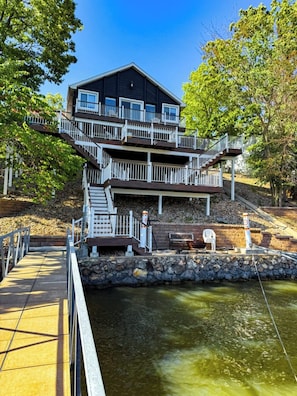 Multi-level lakefront home with direct dock access and multiple decks overlooking the water.