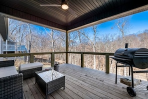 The deck opens up to a wooded backyard.