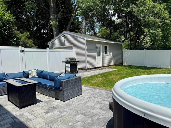 Spacious patio with fire pit, sectional seating, and a pool—perfect for relaxing or entertaining.