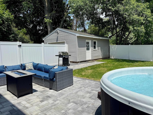 Spacious patio with fire pit, sectional seating, and a pool—perfect for relaxing or entertaining.