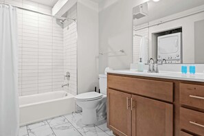 Full Bathroom: A bright, modern bathroom with a tub to help you feel right at home with washer and dryer