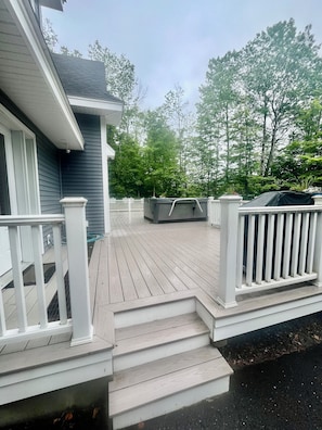 side deck with hot tub , deck furniture and BBQ grill