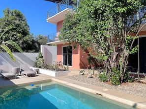 Pool with sundeck, poolside lounger and cooler.