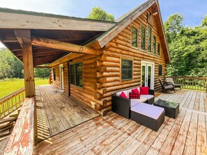 The partially covered wraparound deck flows right into the main living area - complete with vaulted ceilings, wall of windows, and open dining and kitchen space.