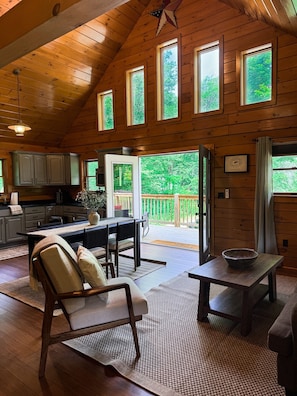 Light-filled and open from every angle—kitchen, dining, and living areas blend seamlessly under soaring ceilings with deck access just beyond.