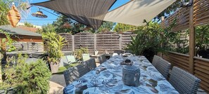 Cette terrasse offre un espace zen parfait pour des dîners. La végétation luxuriante et le buste apaisant invitent à la relaxation. Imaginez déguster un repas sous la toile d'ombrage, bercé par une douce brise.