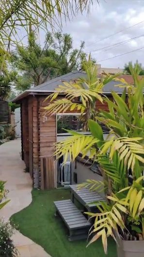 La cabane en bois offre une évasion parfaite au cœur de la nature, où le mobilier extérieur invite à des moments de quiétude en toute simplicité.