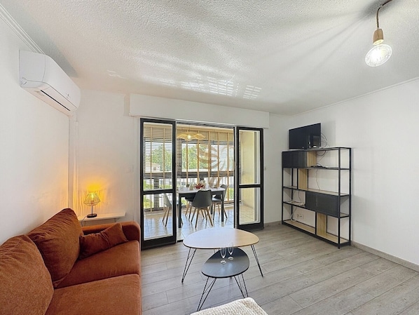 La véranda invite à profiter d'un repas en plein air avec une vue dégagée. La lumière naturelle amplifie l'ambiance chaleureuse de cet espace moderne et fonctionnel.